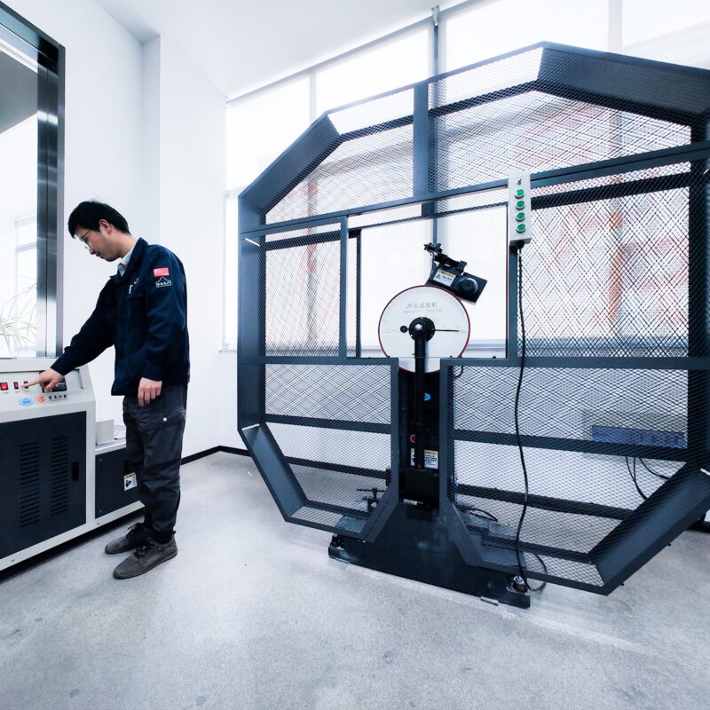 03我们的优势-Motorcycle & Chainsaw Chain Manufacturing | HCC CHAIN Advantages Technician operating enclosed test equipment in the chain inspection laboratory